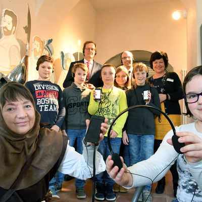 J&uuml;rgen Riecke, Vorstandsvorsitzender der Sparkasse Elbe-Elster, Roland Neumann, Beigeordneter und Kulturdezernent des Landkreises Elbe-Elster sowie Martina P&ouml;schl, wissenschaftliche Mitarbeiterin des Museums (v.l.), &uuml;bergeben die neuen Audioguides.